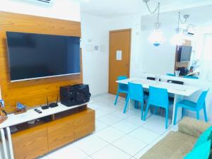 a living room with a tv and a table and chairs at Lindo apartamento em Muro Alto, Porto de Galinhas, Vista para as piscinas, 3 qtos e sala climatizados, Acomoda até 8 pessoas in Ipojuca