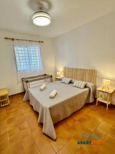 a bedroom with a large bed with two towels on it at APARTBEACH BALANDRO VISTAS MAR in Cambrils