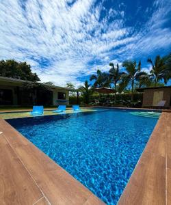 a swimming pool with blue chairs and a blue sky at Casa Carmentea Villa Privada in Acacías