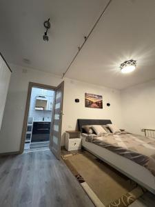 a bedroom with a large bed and a kitchen at Apartmani HeManoS in Duga Resa