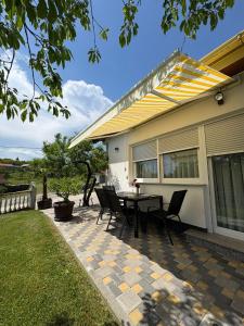 a patio with a table and chairs in front of a house at Apartmani HeManoS in Duga Resa