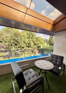 a living room with a table and chairs and a large window at Casa Bosques in Mexico City
