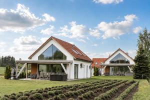 a house with large windows and a garden at Ant House Complex - Luksusowe domy SPA in Ryn