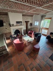 a living room with couches and chairs and a fireplace at Le gite des Menhirs in Mont-Saint-Éloi