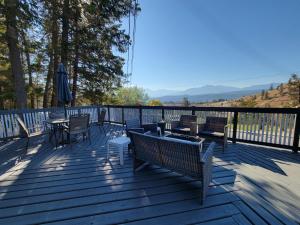 a deck with chairs and tables and an umbrella at Misty River Lodge - in Radium Hot Springs