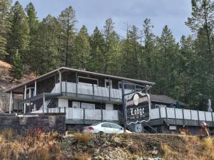 a house with a car parked in front of it at Misty River Lodge - in Radium Hot Springs