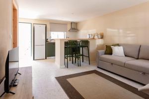a living room with a couch and a kitchen at Casas dos Amigos in Bom Sucesso