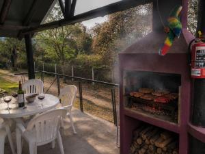 a patio with a table and chairs and a fireplace at El Zorro Cabin Nature and Relaxation near Salta in Salta
