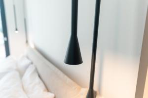 a bedroom with a bed with a black lamp at Avli Residences in Kos +82 photos