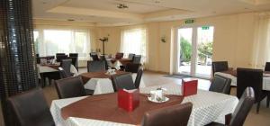a dining room with tables and chairs and tablesktop at Pensiunea Rodica in Nădlac