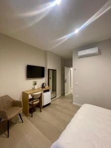 a room with a bed and a desk and a television at Solea Hotel in Vlorë
