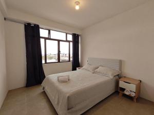a bedroom with a large bed and a window at Casa Hormiga in Panajachel