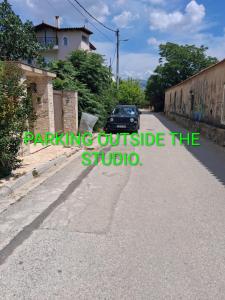 a car parked on a street with the words parking outside the studio at AIRPORT 2 STOPS BY METRO FROM STUDIO & NEAR METRO station "PEANIA-KANTZΑ" in Leondárion