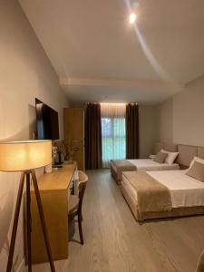 a hotel room with two beds and a couch at Solea Hotel in Vlorë