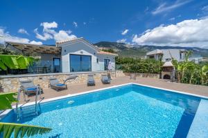 a villa with a swimming pool and a house at Vista Blu Villas in Vlachata