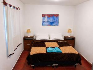 a bedroom with a bed with two blue towels on it at El Zorro Cabin Nature and Relaxation near Salta in Salta +8 photos