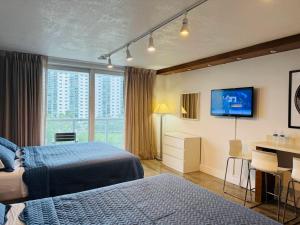 a hotel room with two beds and a flat screen tv at Renovated Beachfront Condo with Balcony in Sunny Isles Beach