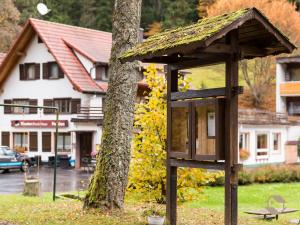 a bird feeder on a tree in front of a building at Enri Theater & Pension Bruderhaus in Altensteig