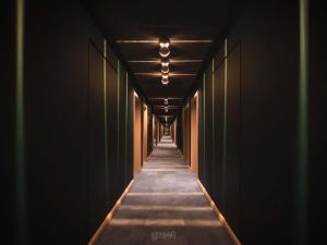 a long corridor with dark walls and a long hallway at greet hotel Cernay Mulhouse in Cernay