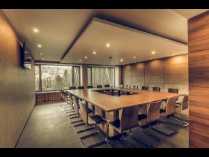 a conference room with a large wooden table and chairs at Hotel Oscar in Campina
