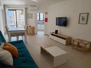 a living room with a couch and a tv at 2F Sao Gabriel - Casas & Papeis in Armação de Pêra