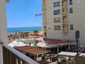 a balcony with a view of a building and the ocean at 2F Sao Gabriel - Casas & Papeis in Armação de Pêra
