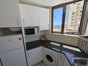 a kitchen with a white refrigerator and a microwave at 2F Sao Gabriel - Casas & Papeis in Armação de Pêra