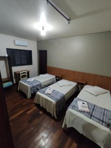 a hotel room with two beds and a window at Hotel Elithi - O melhor custo benefício in Itapeva