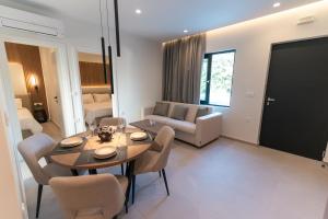a living room with a table and chairs and a couch at Avli Residences in Kos