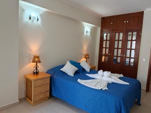 a bedroom with a blue bed with two white towels at 2F Sao Gabriel - Casas & Papeis in Armação de Pêra +13 photos