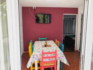 a dining room table with colorful chairs and a tv at El Zorro Cabin Nature and Relaxation near Salta in Salta