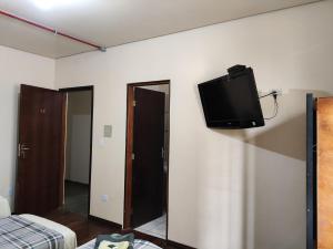 a flat screen tv on the wall of a bedroom at Hotel Elithi - O melhor custo benefício in Itapeva +99 photos