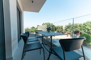 a balcony with chairs and a table with a view at Avli Residences in Kos