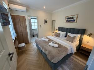 a bedroom with a large bed with two towels on it at Heritage Villa Francheza-Elegant Stone villa near the Beach, Pašman Island , Ugrinić in Ugrinići +44 photos