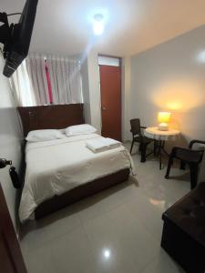 a bedroom with a bed and a table with a lamp at hospedaje encantada in Cajamarca +2 photos