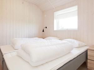 a white bed in a room with a window at Luxury Retreat with Spa - By Traum Ferienwohnungen in Bøtø By
