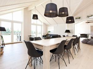a dining room with a large wooden table and chairs at Luxury Retreat with Spa - By Traum Ferienwohnungen in Bøtø By +26 photos