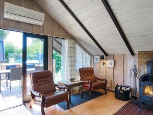 a living room with two chairs and a fireplace at 5 person holiday home in Dannemare in Dannemare