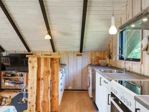 a kitchen with wooden walls and a counter with a sink at 5 person holiday home in Dannemare in Dannemare +36 photos
