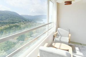 a room with two chairs and a large window at 箱根芦ノ湖 HOTEL RaKuun in Hakone