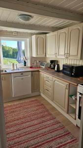 a kitchen with white cabinets and a large window at Fjordhuset på Helgelanskysten in Leirfjord +45 photos
