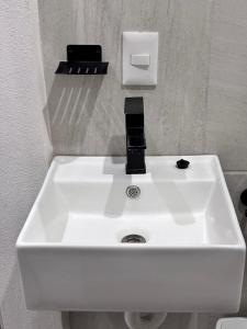 a white sink in a bathroom with a dispenser at La Isla Studio - Quimixto in Qumiste +27 photos