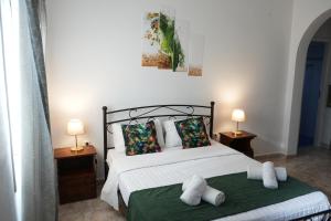 a bedroom with a bed with towels on it at Green Parrot Apartments in Frátsia