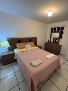 a bedroom with a bed with two towels on it at Mexican House in Mexico City
