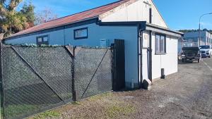 a blue building with a fence in front of it at The Central Apartment in Geraldine +1 photo
