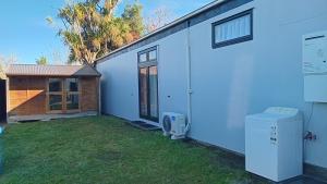 a white house with a yard next to a building at The Central Apartment in Geraldine