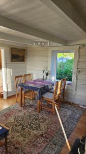 a dining room with a table and chairs and a rug at Fjordhuset på Helgelanskysten in Leirfjord