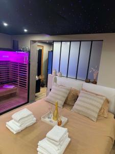 a bedroom with a large bed with towels on it at L'annexe étoilée in Couvin