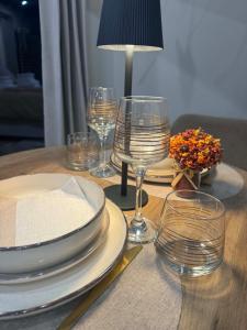 a wooden table with plates and wine glasses on it at L'annexe étoilée in Couvin