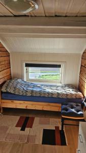 a bed in a small room with a window at Fjordhuset på Helgelanskysten in Leirfjord